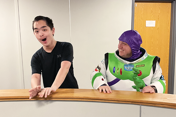 Heartspring Therapeutic Residential & Day School student stands next to special education teacher, Alex Kimmel dressed as Buzz Lightyear from "Toy Story."