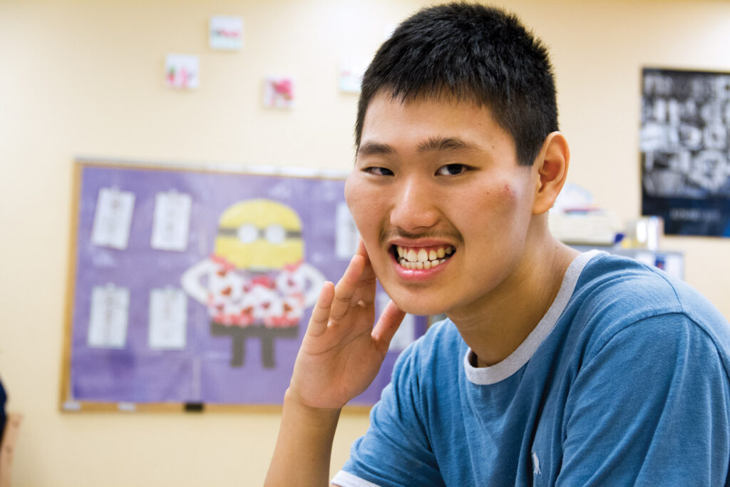 Heartspring student sitting and smiling at the camera