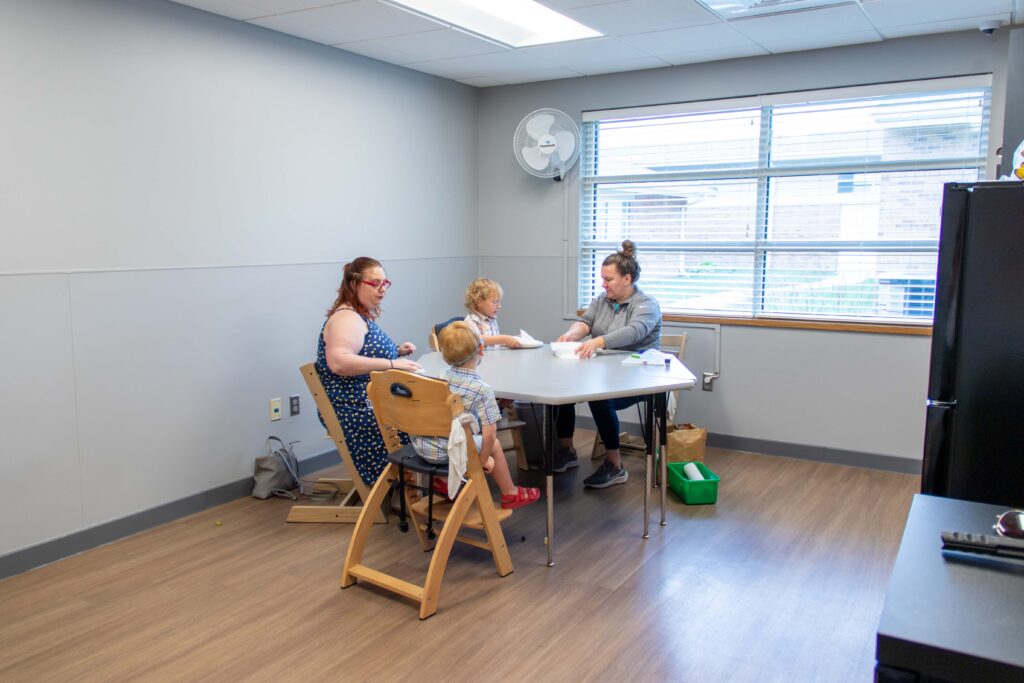 Heartspring pediatric feeding therapist and a family sit around a table during a feeding therapy session