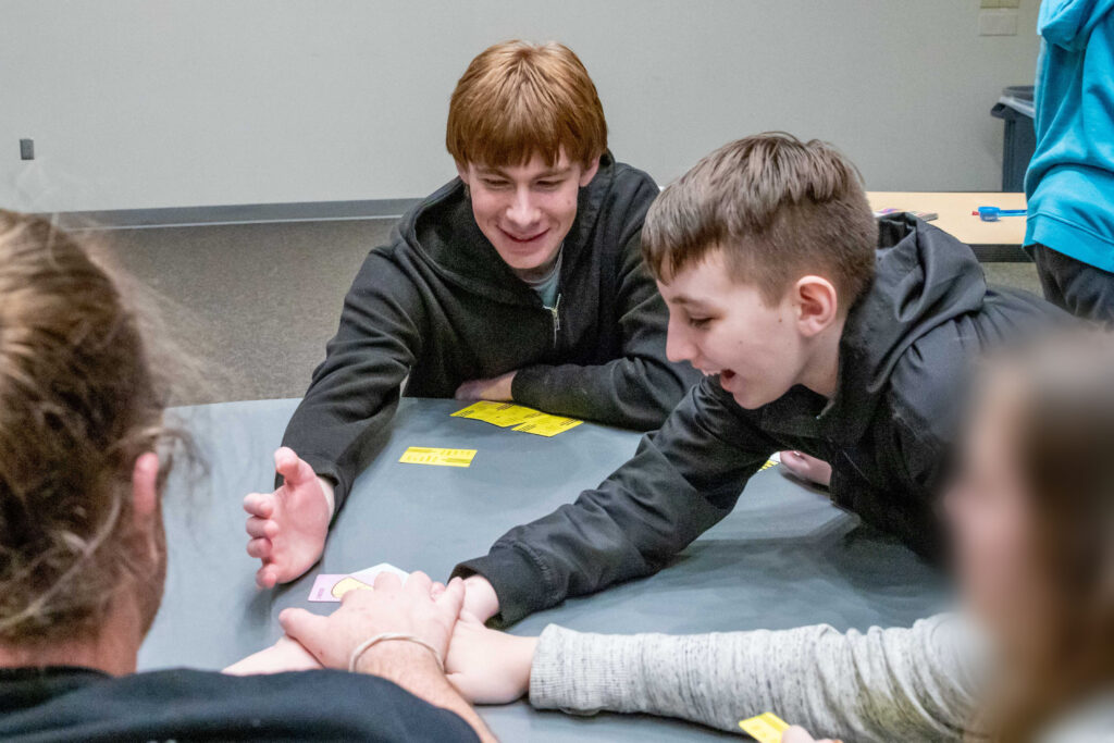 Teenage CARE Clubs clients playing a card game around a table