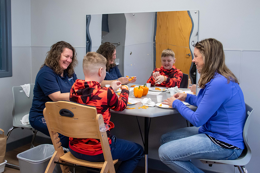 Heartspring feeding therapist working with a client on introducing new foods in a pediatric feeding therapy session
