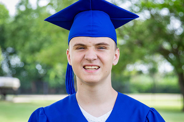 Heartspring student graduate wearing a blue cap and gown