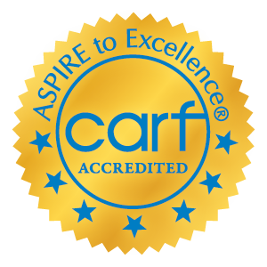 CARF International Seal Gold seal with sharp, scalloped edges with blue "CARF Accredited" text inside the middle of the circle. "ASPIRE to Excellence" is across the top and stars are on the reverse side of the circle.