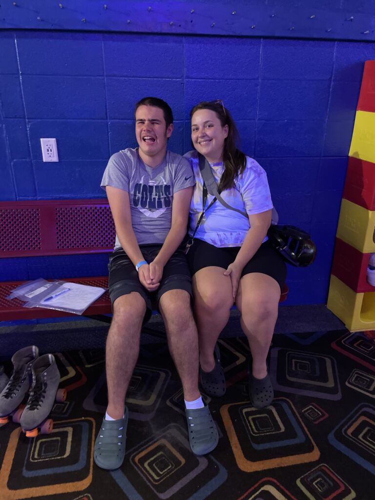 Heartspring direct support professional and student smiling for the camera at a skating rink