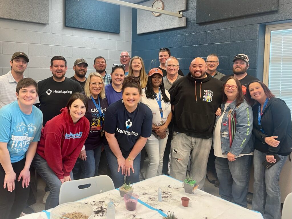 A group of Heartspring employees posing for the camera during an employee art day