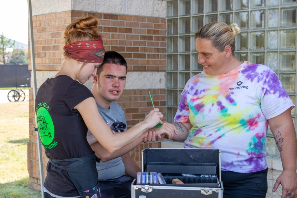 Heartspring student getting his hand painted during Family Weekend