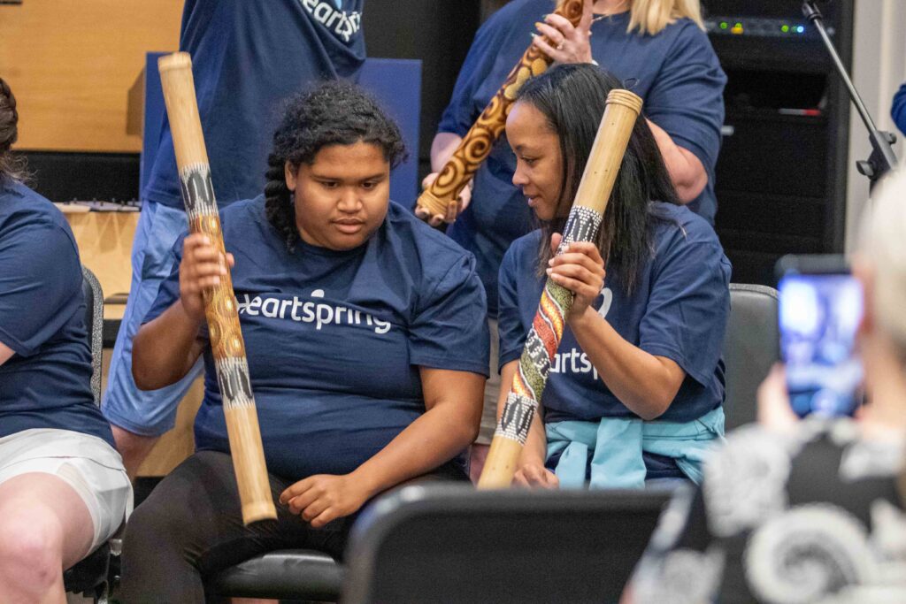 Heartspring direct support professional and student playing musical instruments during the music program at Family Weekend
