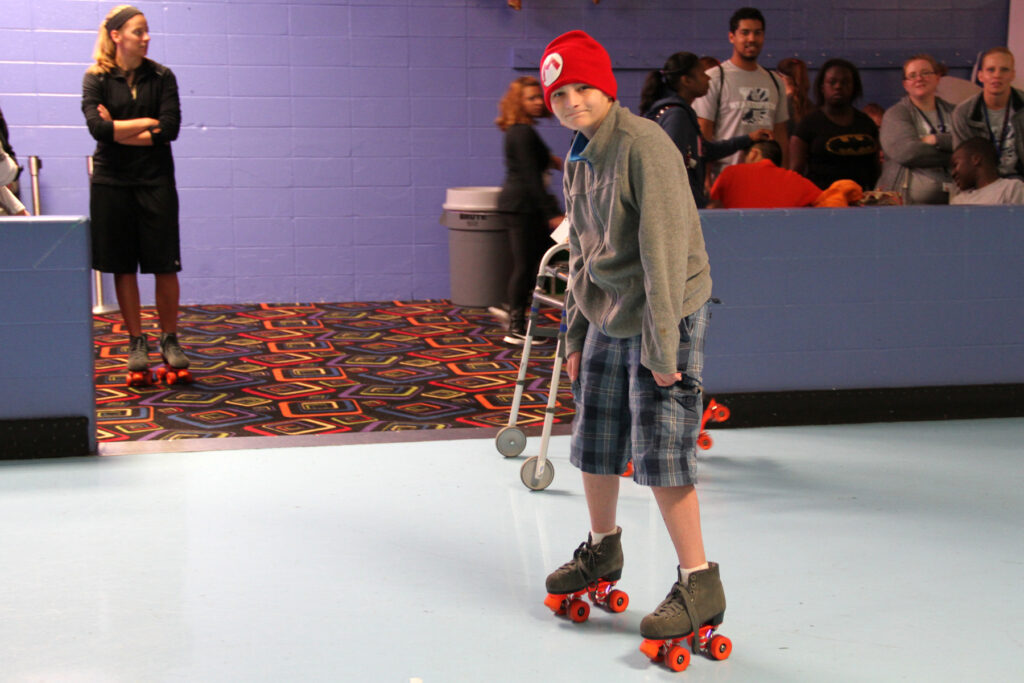 Heartspring student John smiling at the camera and skating at the local skating rink