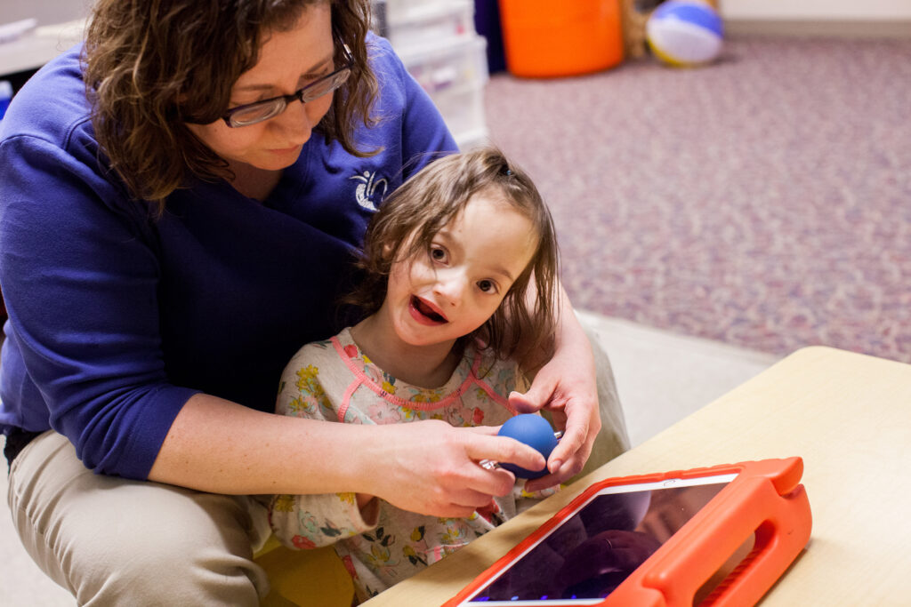 Heartspring occupational therapist working with Magnolia on motor skills during a pediatric occupational therapy appointment
