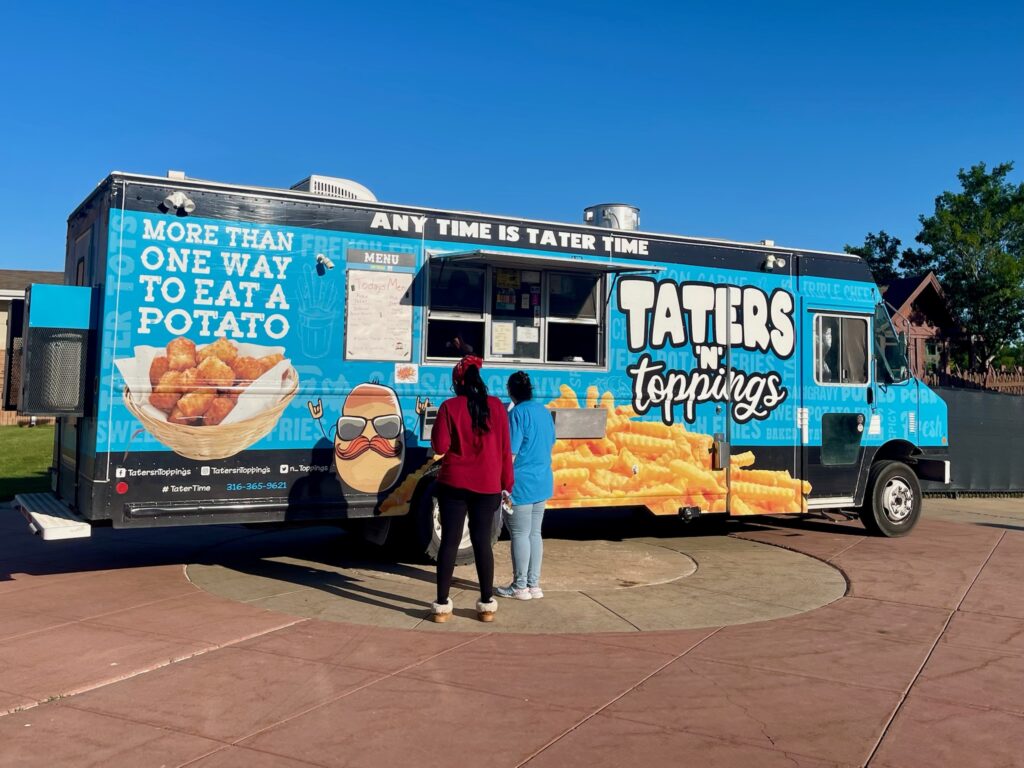 Employees waiting in line at the Taters N Toppings food truck on campus