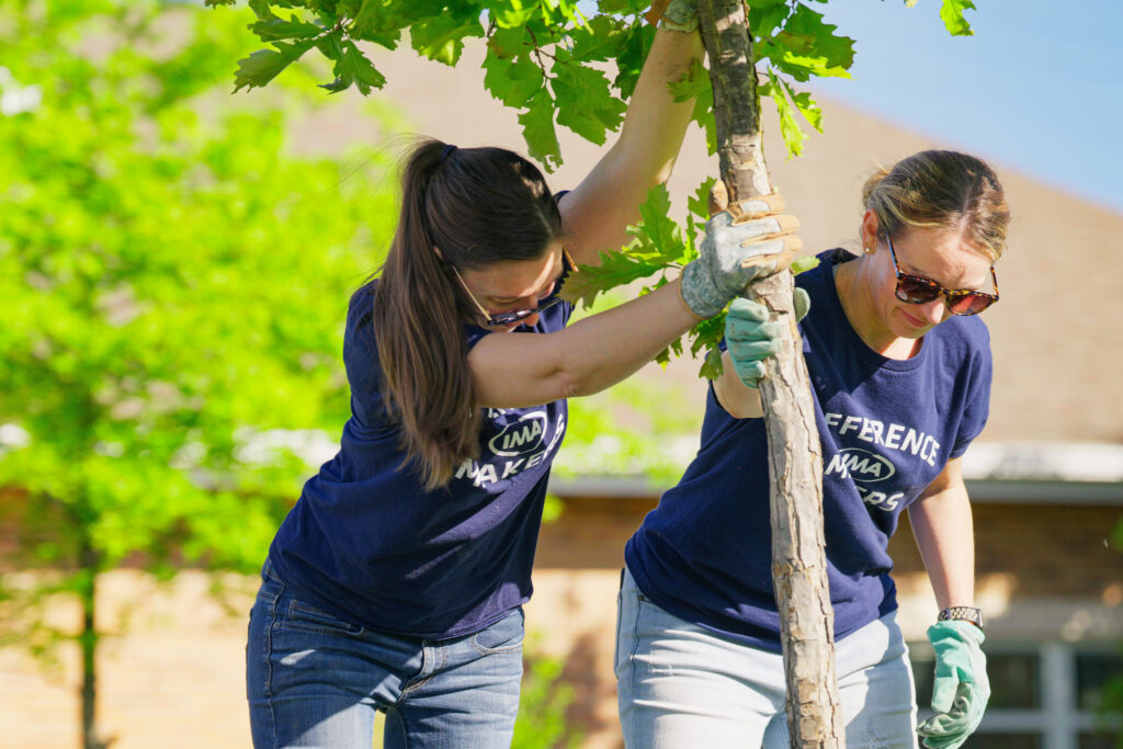 IMA volunteers planting a tree in the Heartspring courtyard