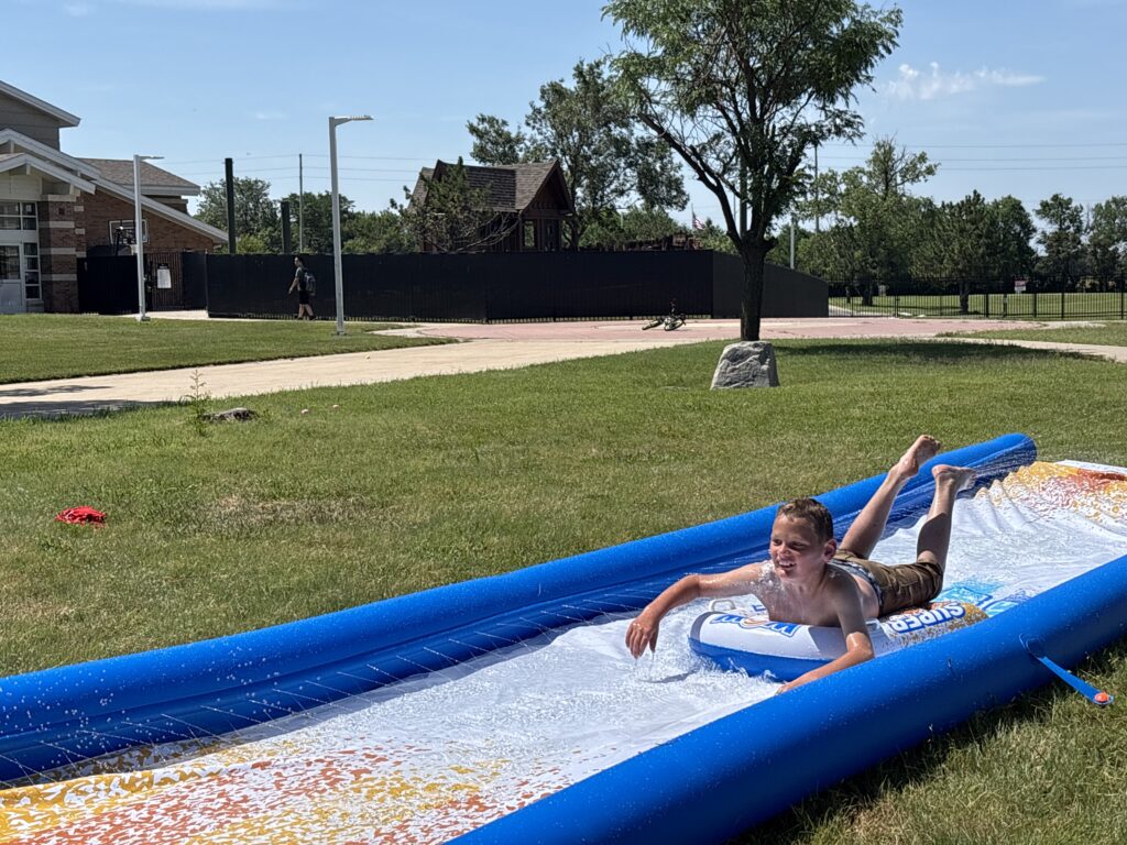 Heartspring Therapeutic Residential & Day School student enjoys the slip and slide at Family Field Day.