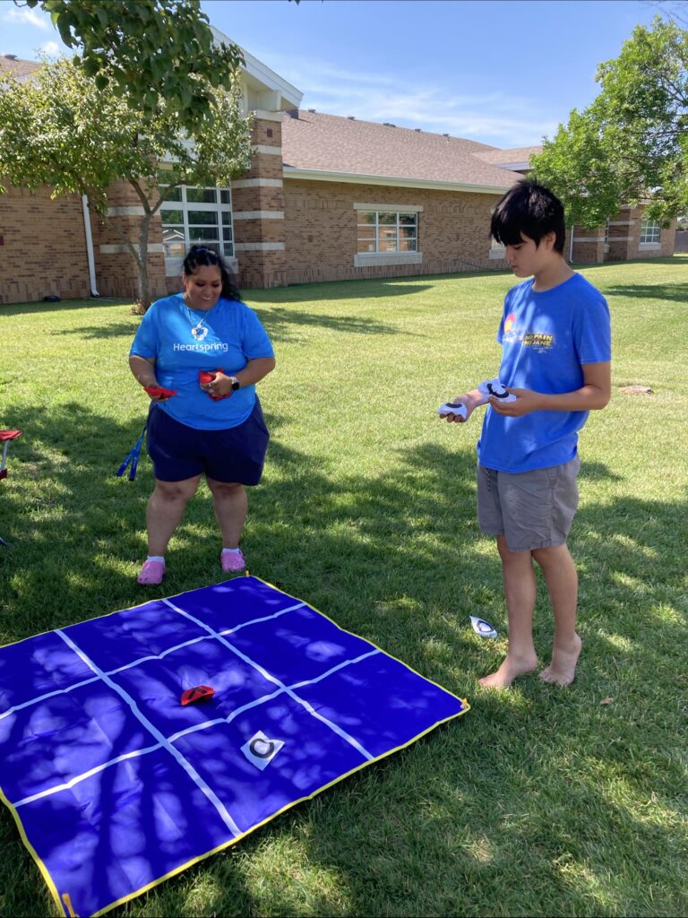 Heartspring Therapeutic Residential & Day School student plays a game of tic-tac-toe at Family Field Day.