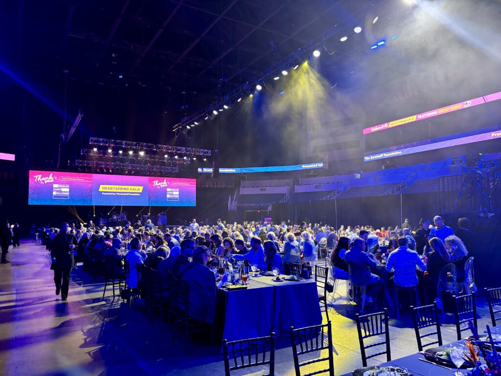 Wide crowd shot of guests eating dinner in INTRUST Bank Arena at the 2025 Heartspring Gala