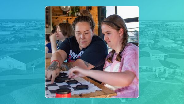 Values Ambassador, and Heartspring Therapeutic Program Direct Support Professional, Abigail Castro plays checkers with a student at a residential outing.