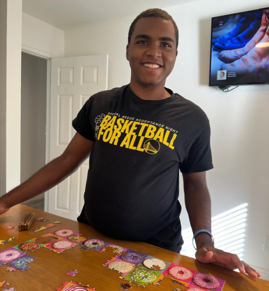 Former Heartspring Therapeutic Residential & Day School student enjoys life after graduation, solving a jigsaw puzzle.
