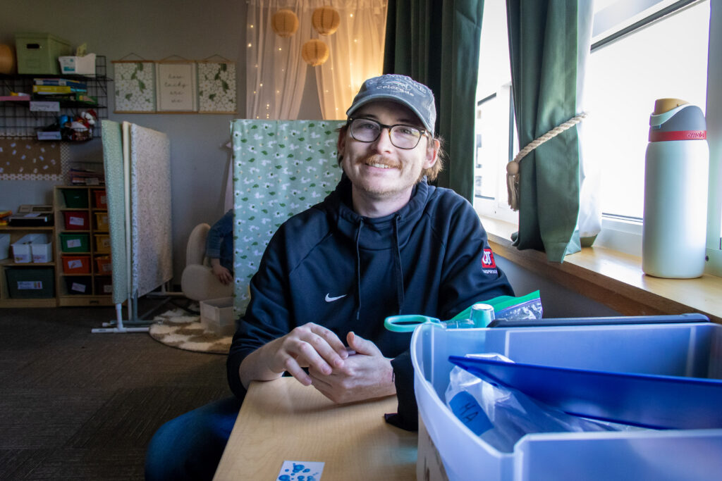 Values Ambassador Brach Bradford, a registered behavior technician (RBT) sets up an activity in an applie behavior analysis (ABA) therapy space.