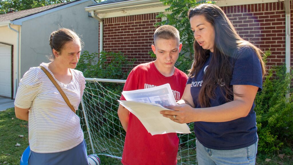 Brandon goes over the visual support document with his occupational therapist and physical therapist.