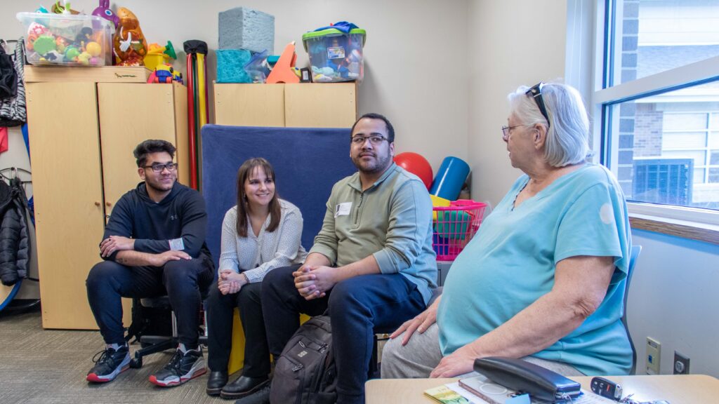 Brandon's grandmother, Terry, discusses the project with three Wichita State University engineering students.