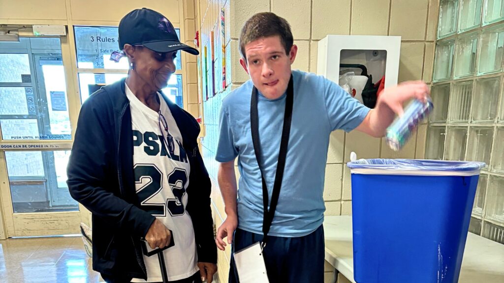 Gloria Phillips, a paraprofessional lead in the Heartspring Therapeutic School helps a student complete his recycling vocational activity.